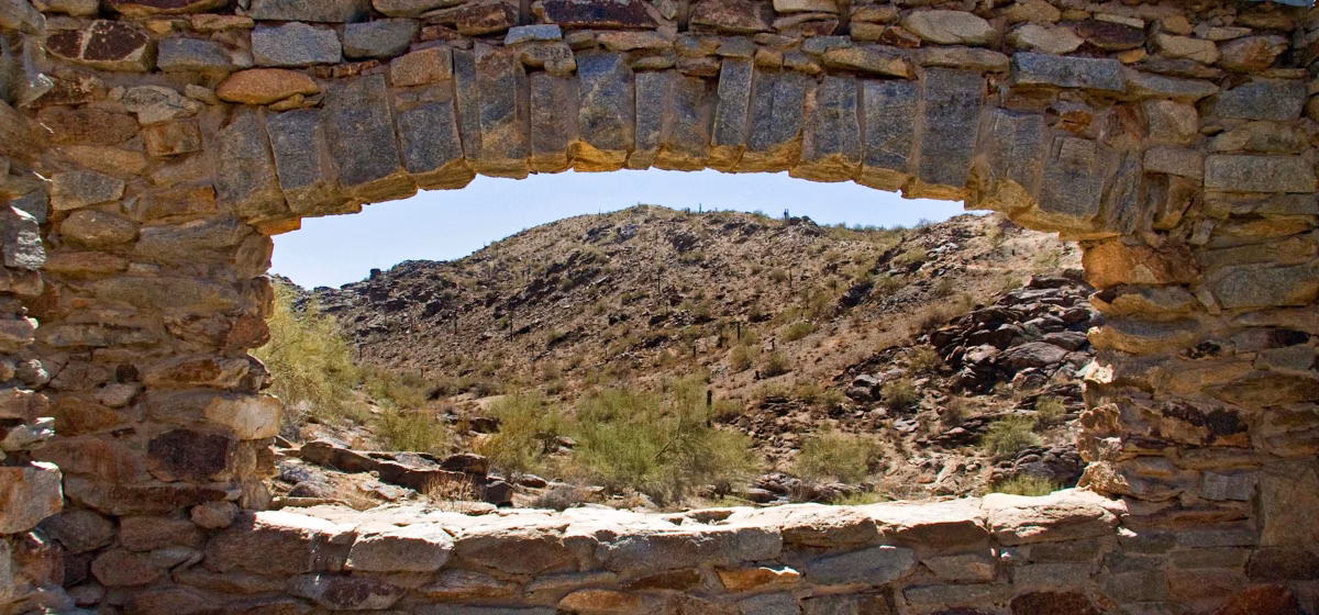 Desert hills seen through the arched stone window of the Dobbins Lookout ramada