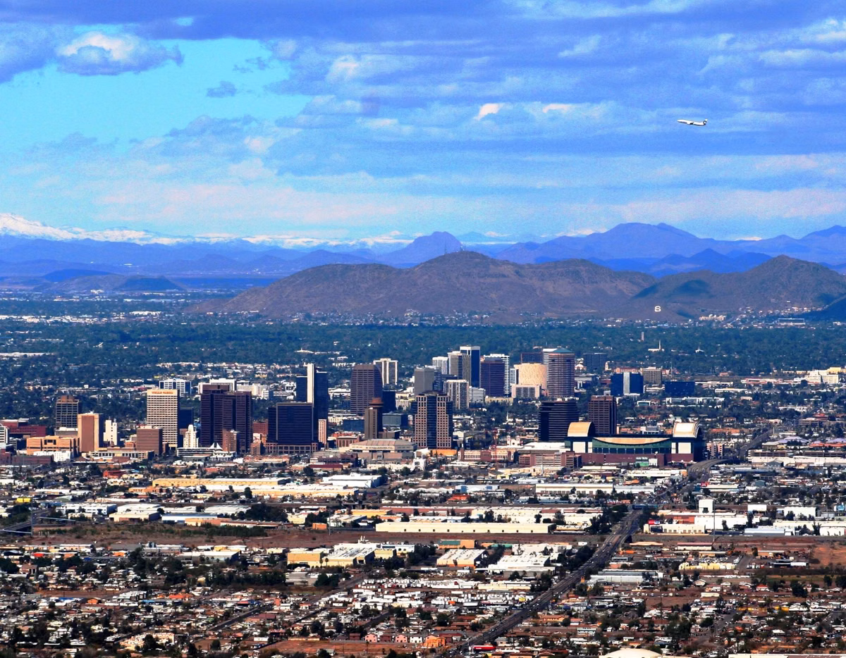 Downtown Phoenix high-rises and the city grid seen from South Mountain, with distant mountain ranges