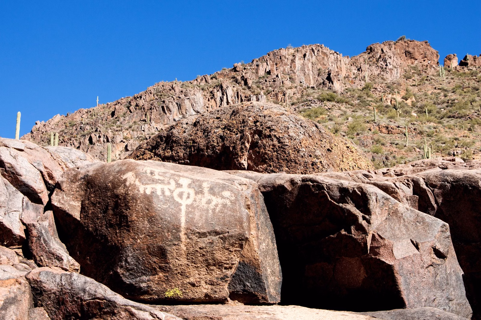 A petroglyph on a boulder below a rocky ridge in the Superstition Mountains east of Phoenix
